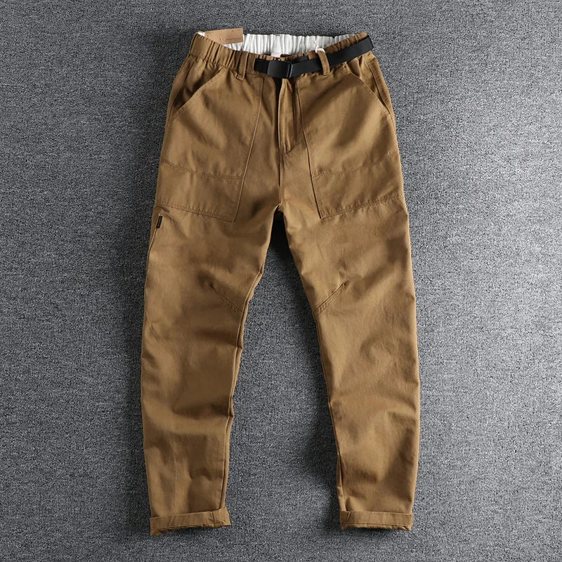 Men's khaki cotton work trousers with N I buckle belt and three-dimensional cut on a hanger.