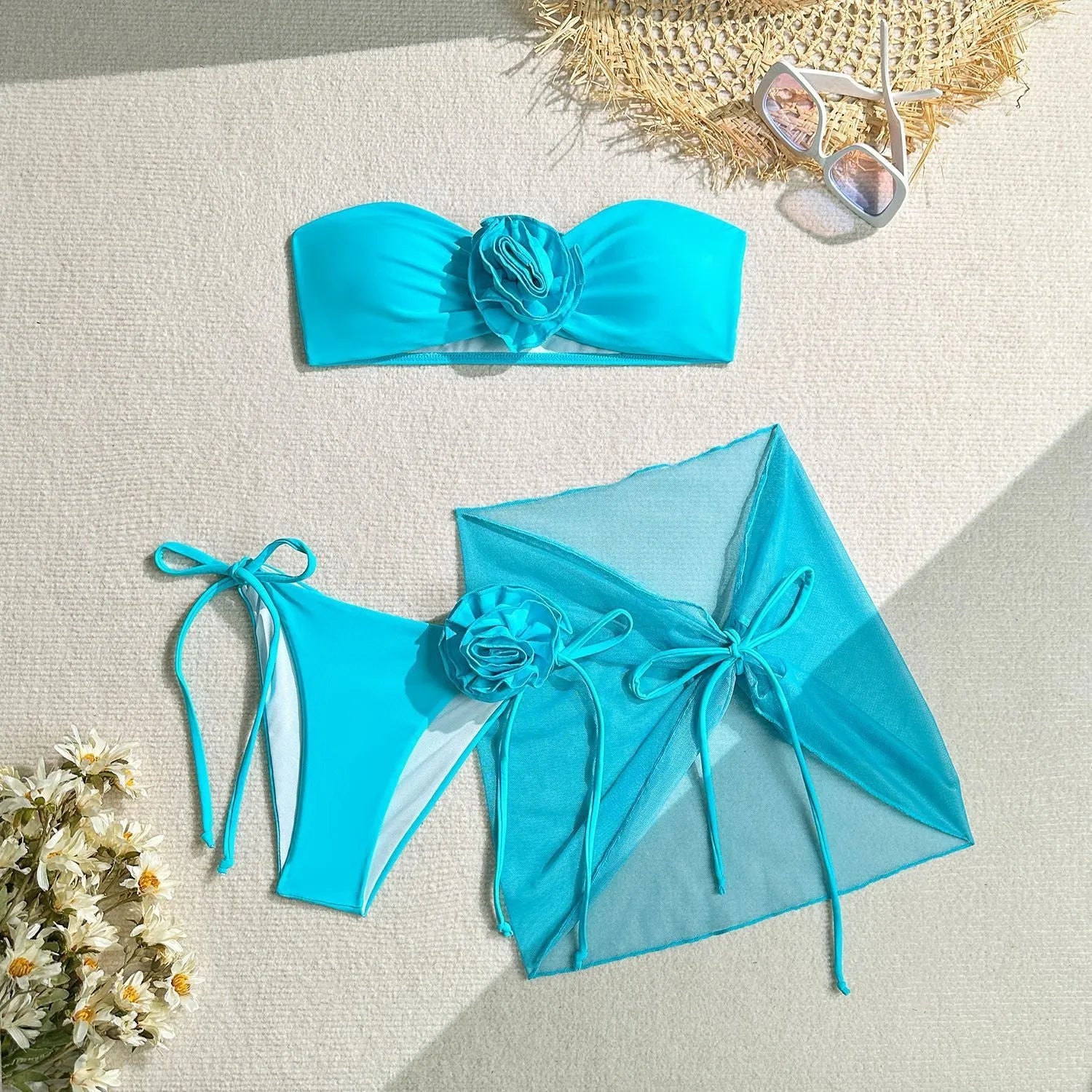 Women's pink tube top swimsuit with 3D flower detail, matching pants, and skirt laid flat.