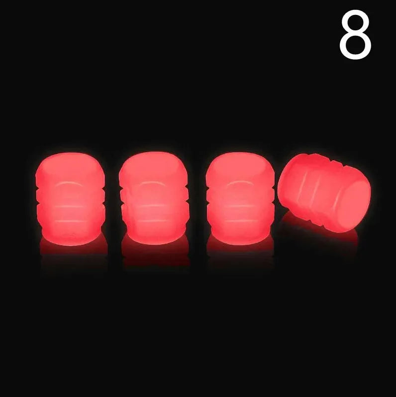 Pack of green and blue luminous rubber tyre valve caps on a car tyre valve.
