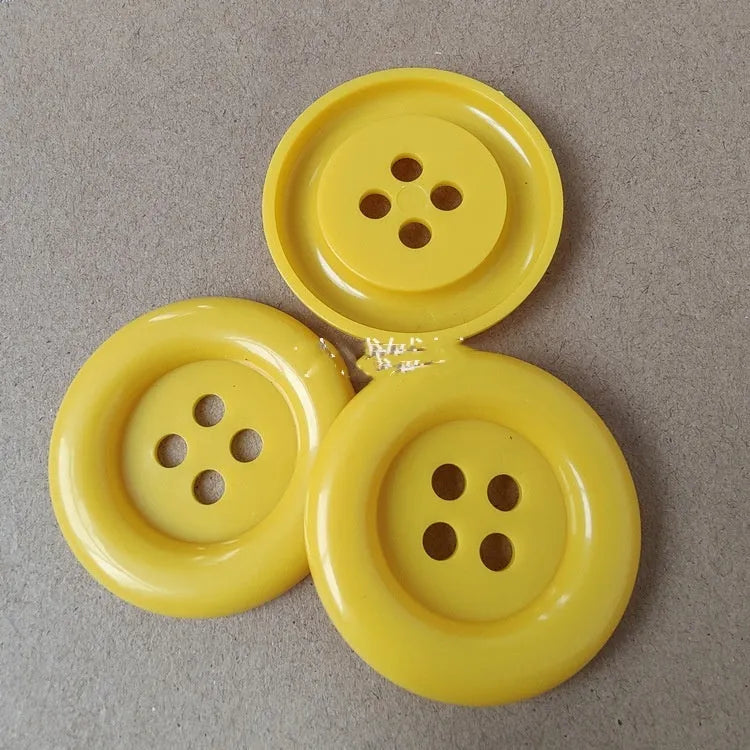 Oversized round plastic sewing buttons in multiple colours with four holes