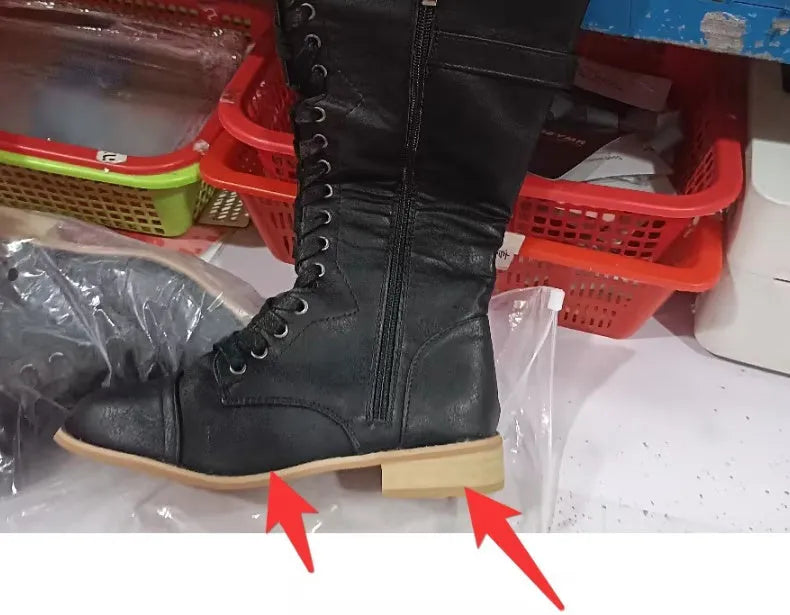 Women's black artificial PU knight boots with cross straps and buckle fastenings.