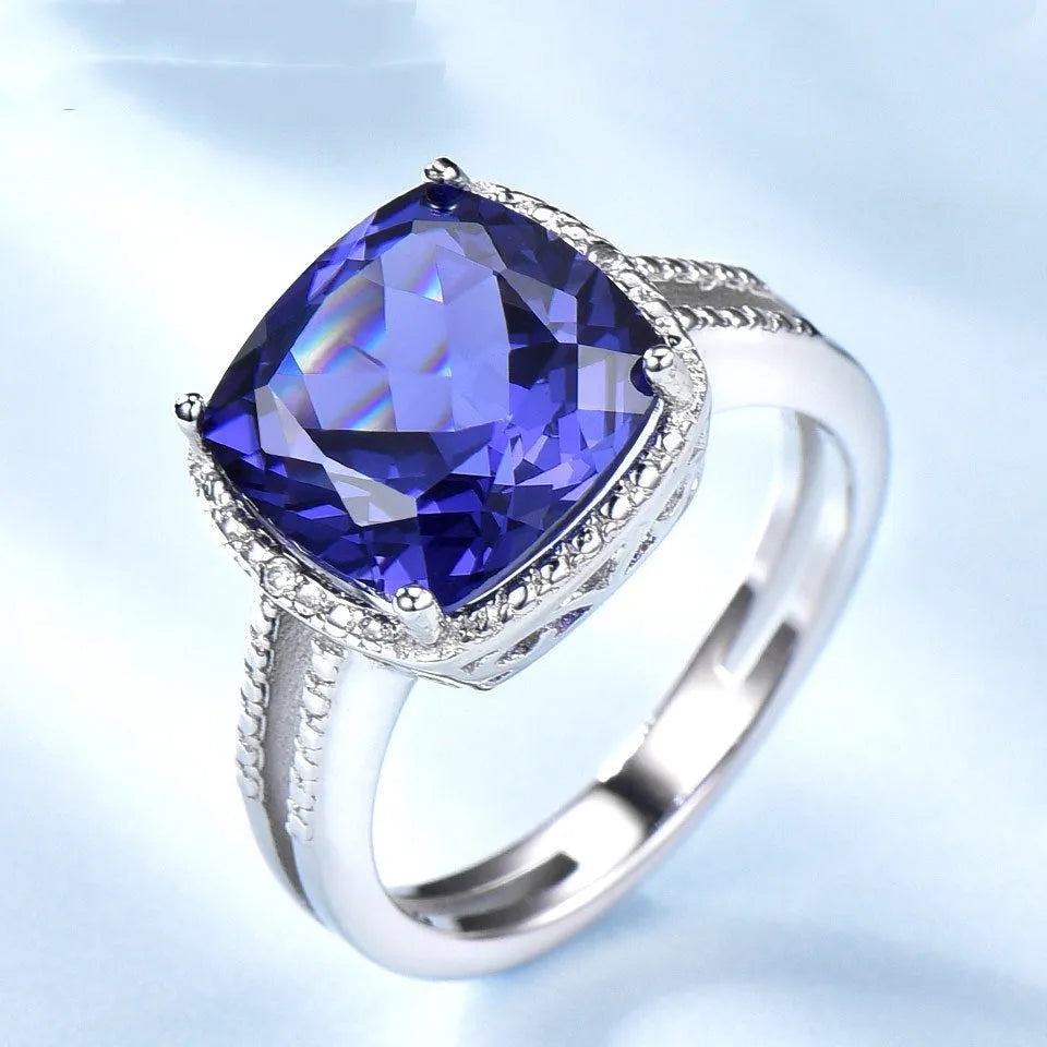 Women's sterling silver ring with a blue Tanzanite gemstone, shown in UK size options 6 to 10.