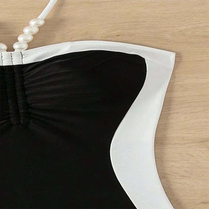 Black and white women's one-piece swimsuit with spaghetti straps and slim fit design