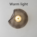 Round glass wall lamp in a choice of colours for bedroom bedside lighting.
