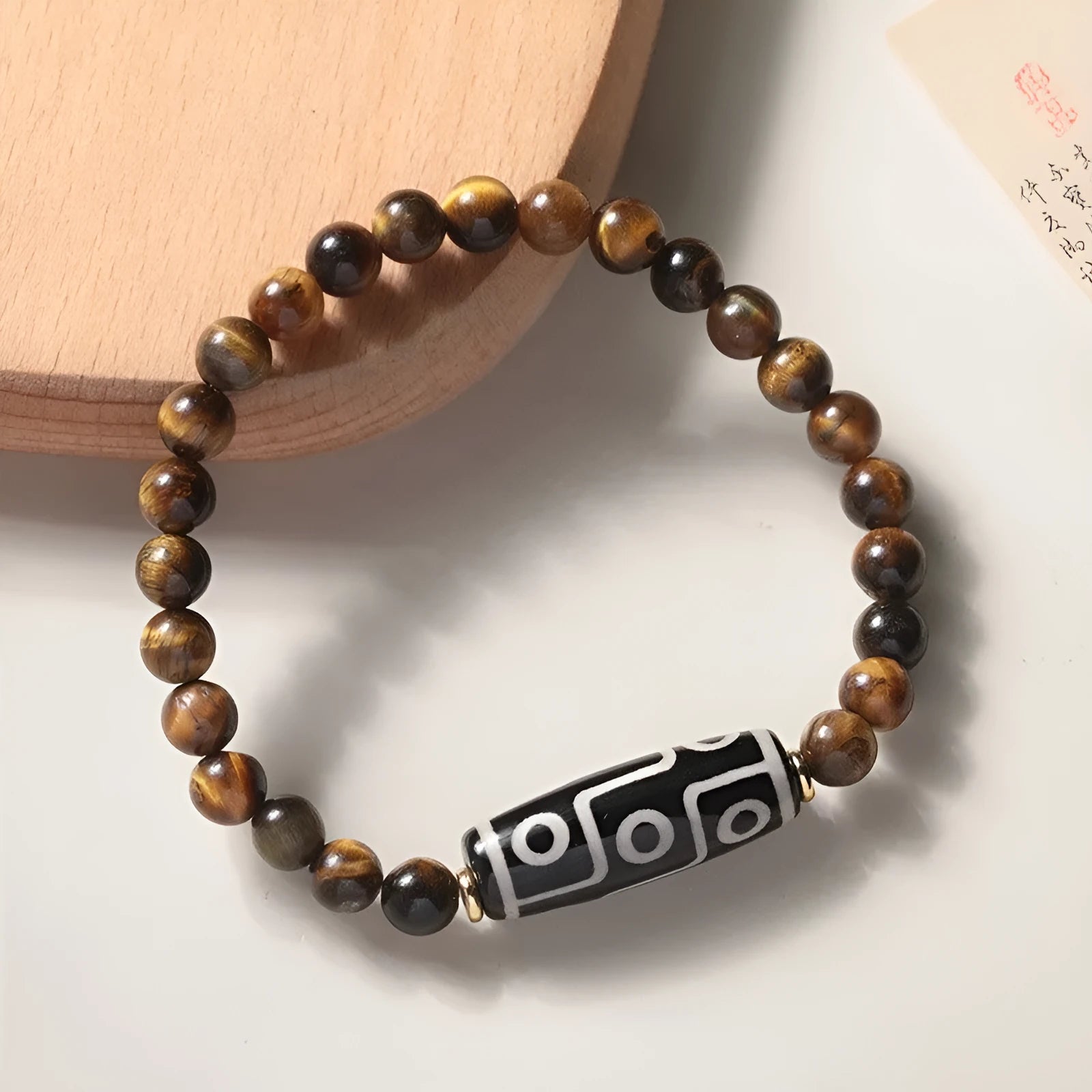 Single circle tigereye stone Buddhist prayer beads bracelet on wrist, showing ethnic design.