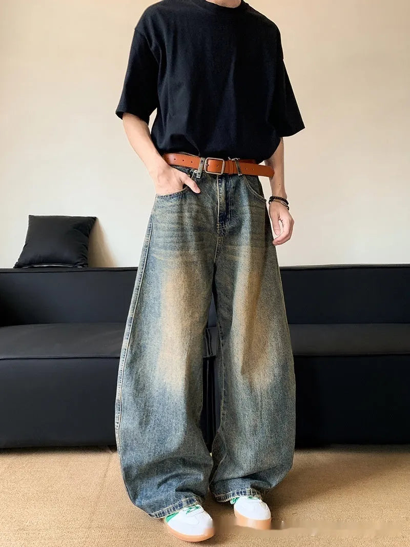 Man wearing retro blue distressed wide-leg denim trousers with a slimming fit.