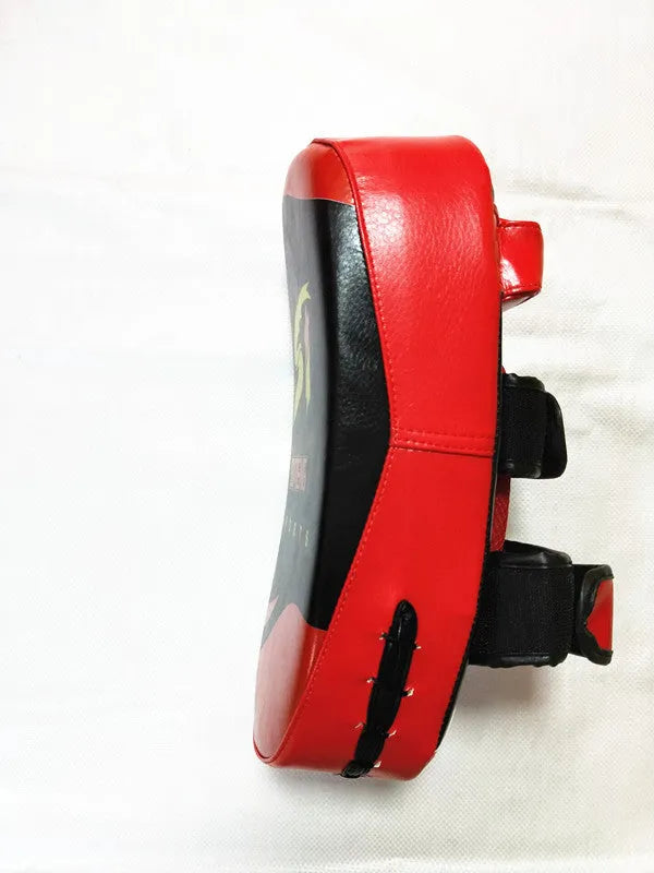Black and red hand-held martial arts target pad with buckle strap on the back.