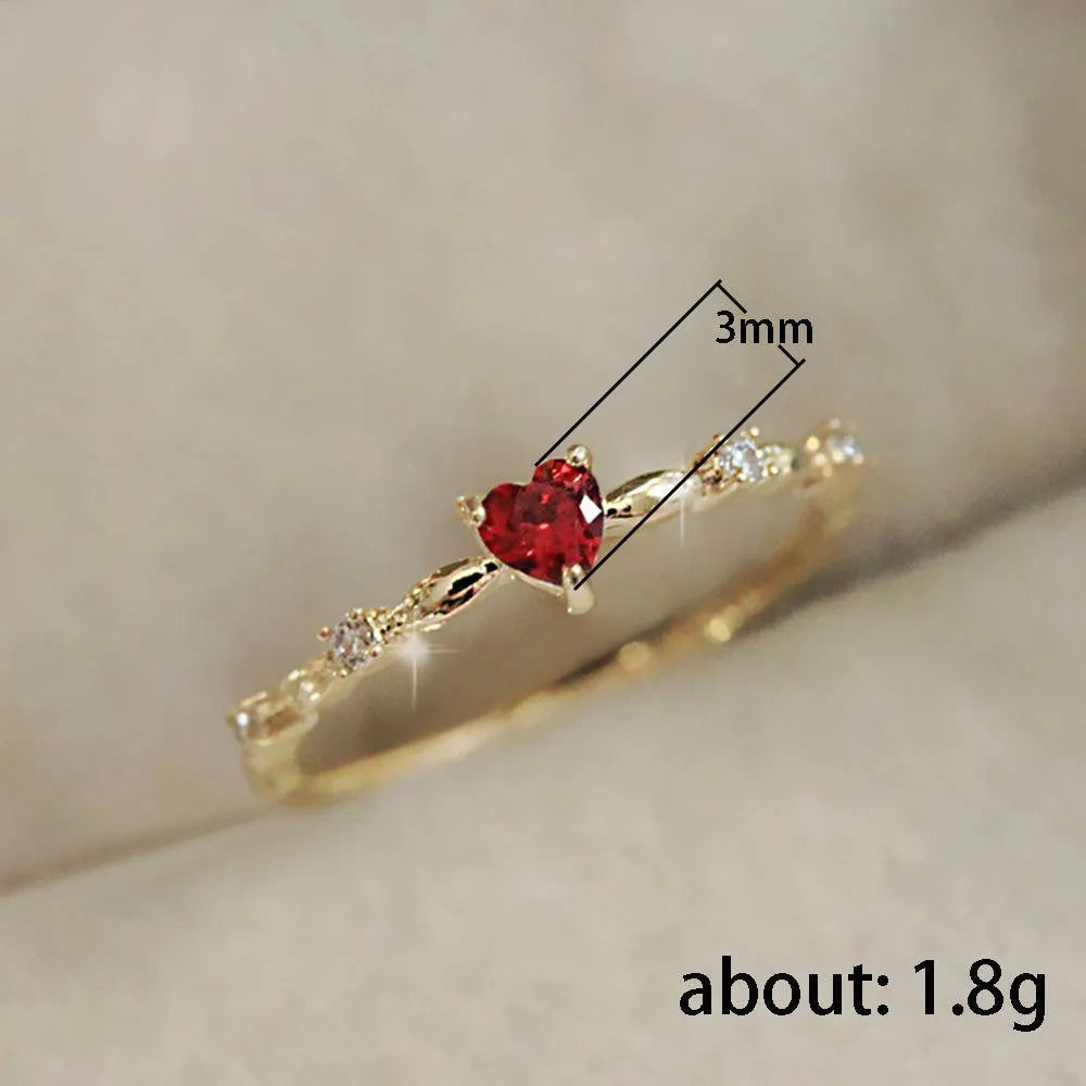 Gold tone peach heart ring with zircon stone centre on finger