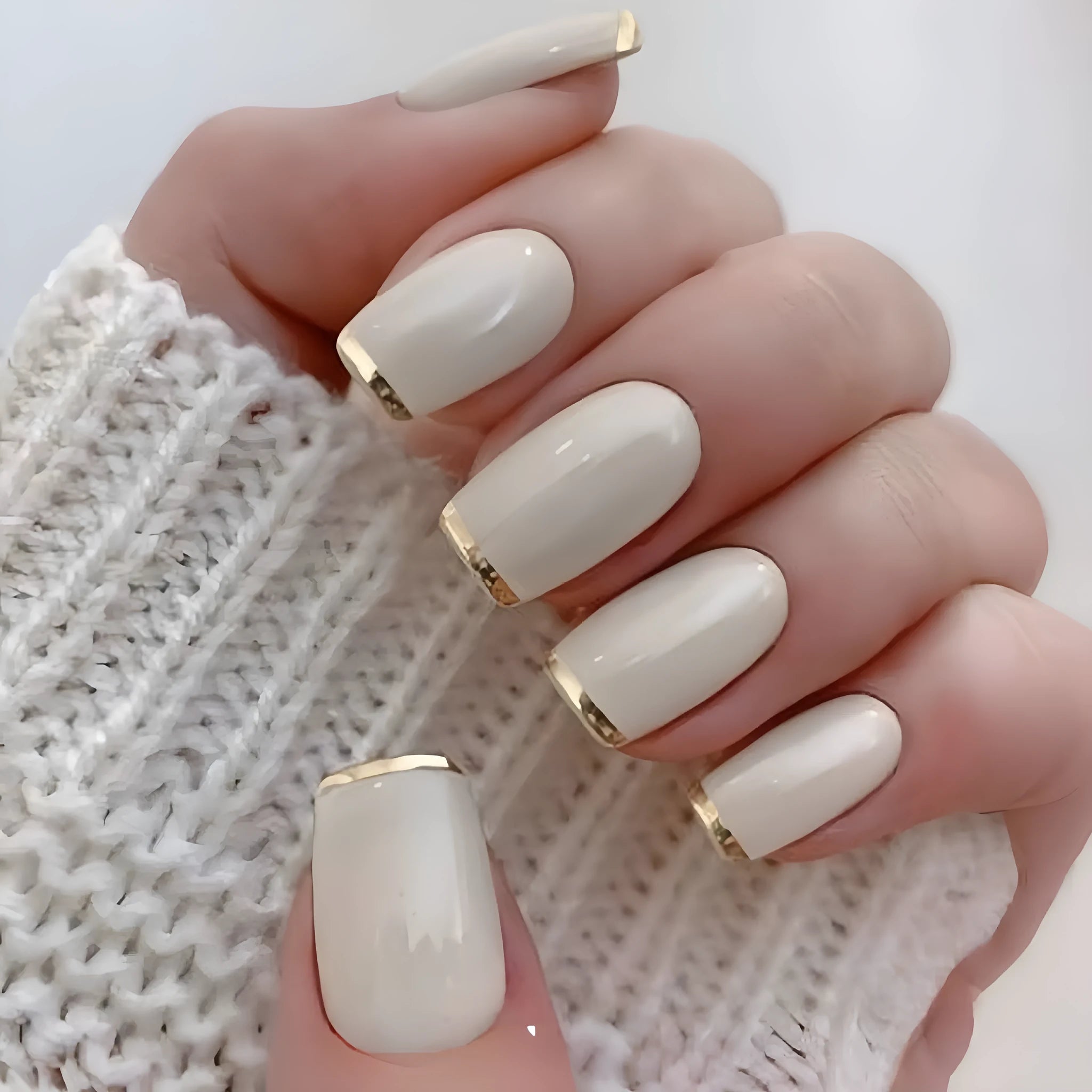 Mid-length European square nail art patch with white French tip and golden edge on a natural nail