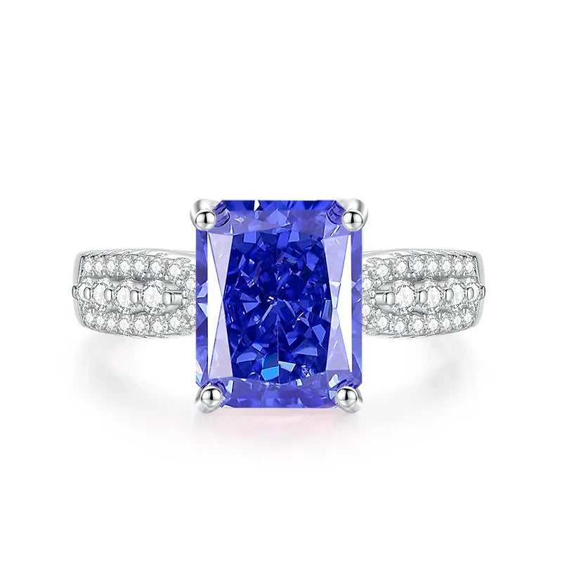 Women's heart-shaped sterling silver ring with ice flower cut coloured zircon stone on finger.