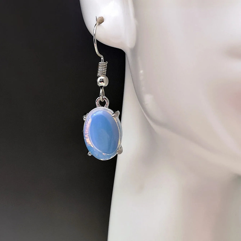 A pair of retro-style drop earrings with a moonlight opal colour and simple cross detail.