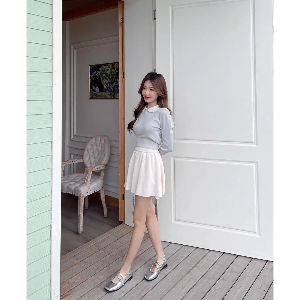 Women's silver leather Mary Jane flats with a cross buckle strap and flat sole.