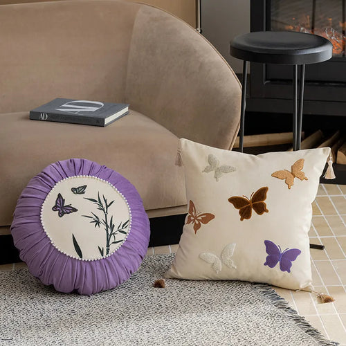 Square beige cushion with detailed black butterfly embroidery in a Chinese style pattern.