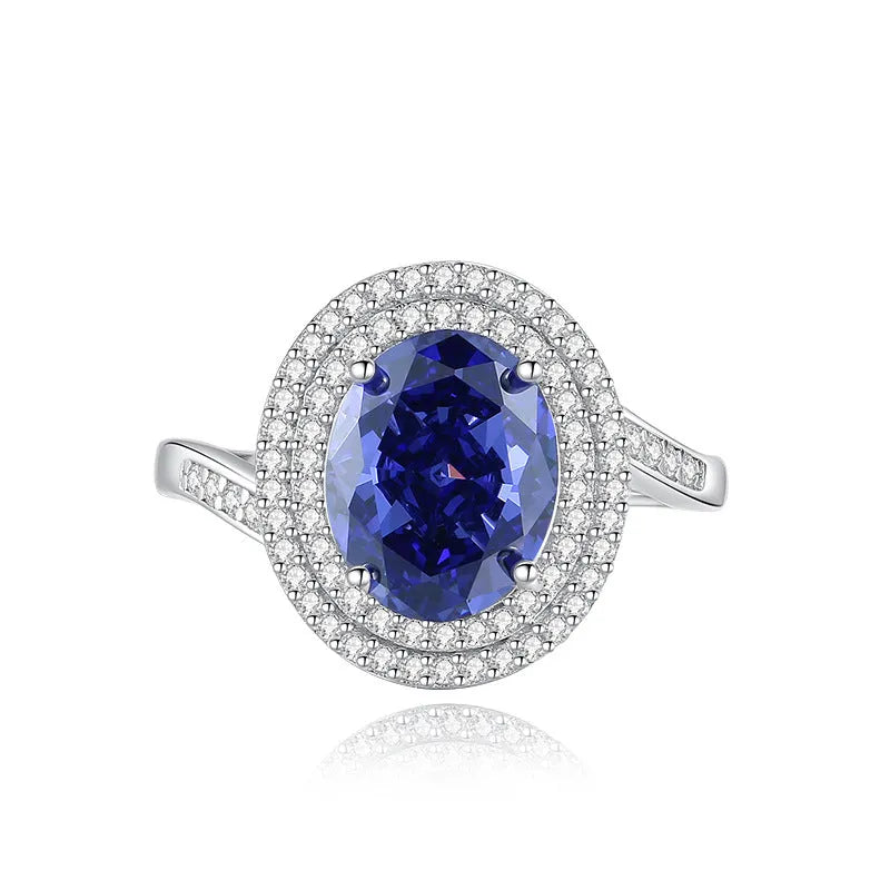 Women's heart-shaped sterling silver ring with ice flower cut coloured zircon stone on finger.