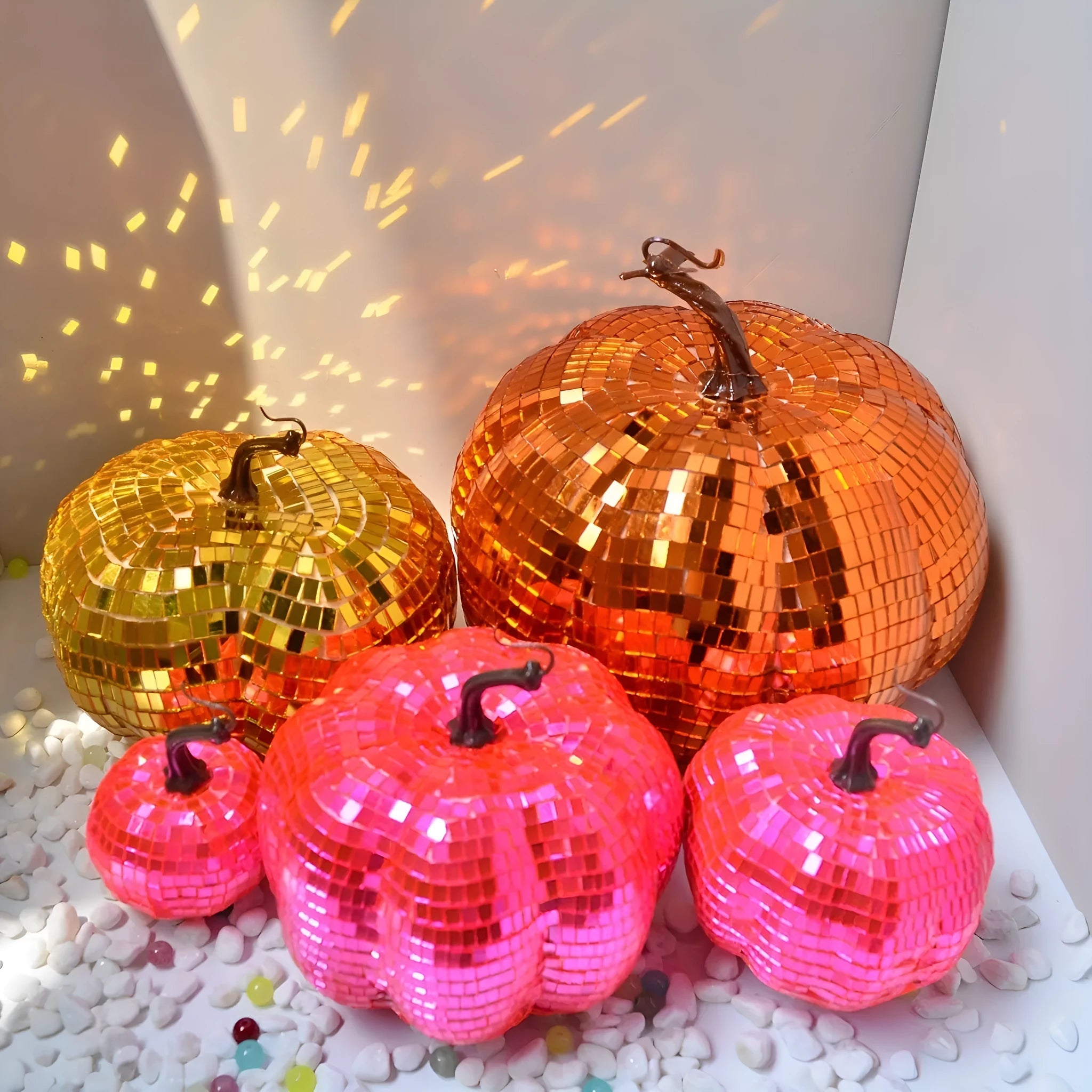 Chinese-style mirror glass pumpkin Halloween decoration in various sizes on a shelf.