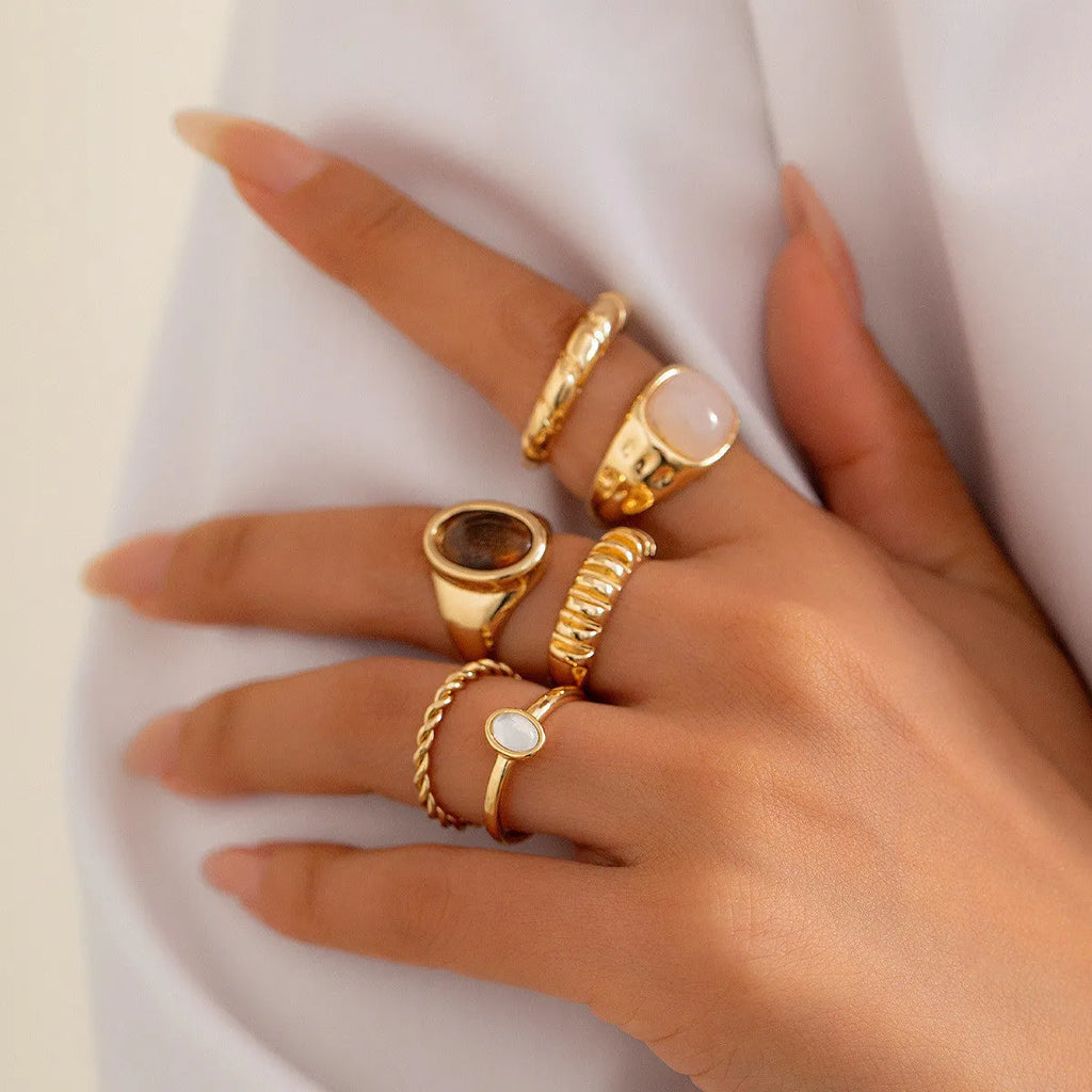 Six geometric light gold alloy rings arranged in set with electroplated finish