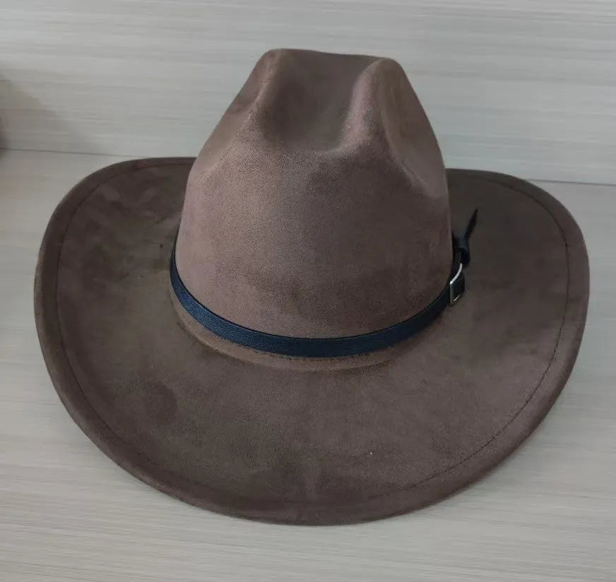 Brown leather velvet curved edge Western cowboy hat with a conical crown on a table.
