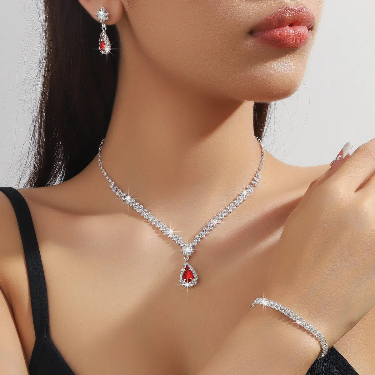 Claw chain necklace and matching earrings set with drop-shaped rhinestones in multiple colour options