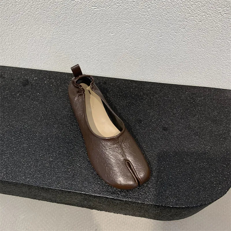 Women's black chunky low heel pumps with round toe and split toe horseshoe design on a rubber sole.