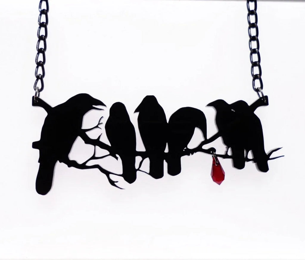 Black electroplated alloy crow pendant necklace on a cross chain for women.