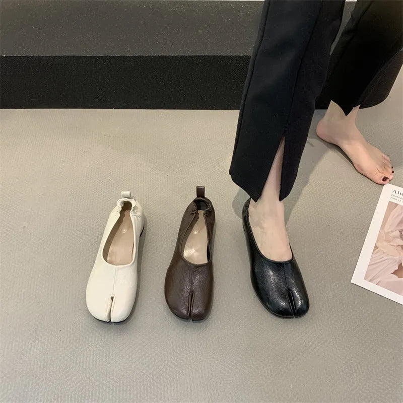 Women's black chunky low heel pumps with round toe and split toe horseshoe design on a rubber sole.