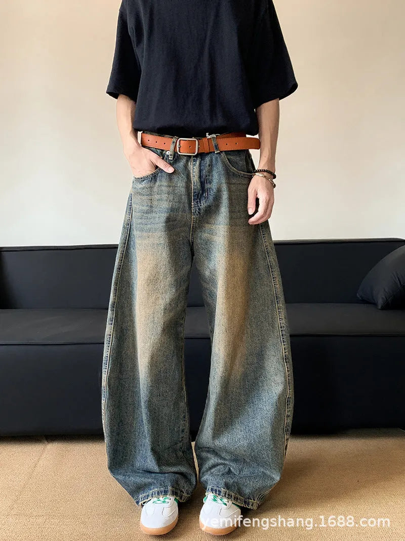 Man wearing retro blue distressed wide-leg denim trousers with a slimming fit.