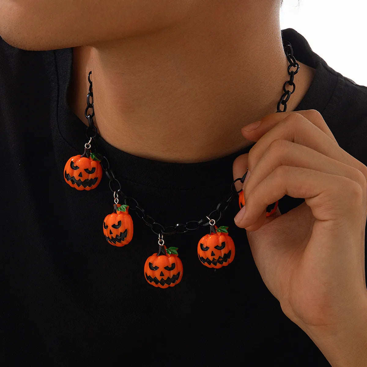 Halloween necklace with ghost and pumpkin cartoon pendants on a chain, in mixed colours.