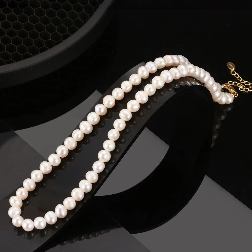 Women's adjustable silver necklace with natural freshwater pearls on a model.