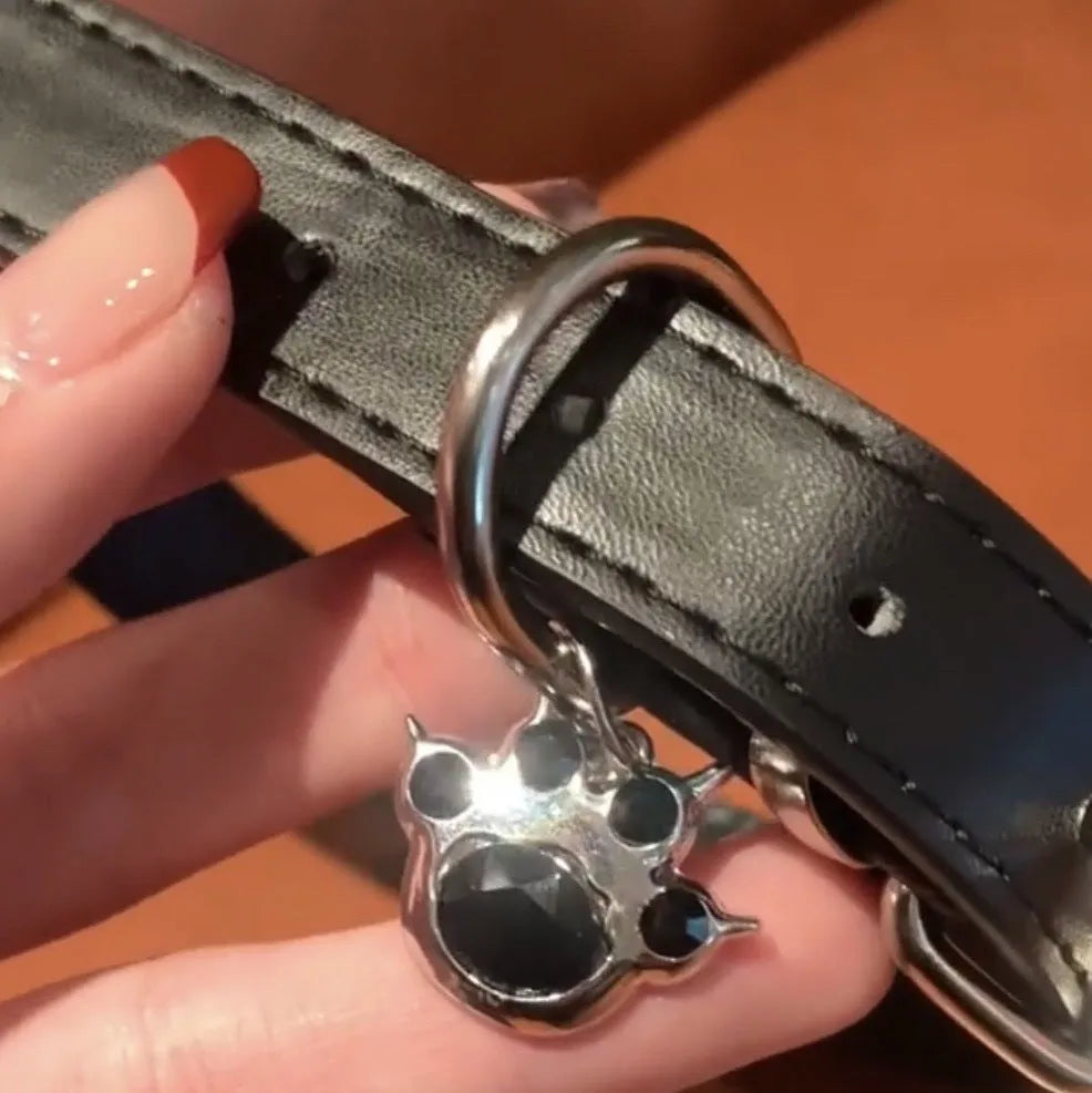 Black adjustable dog collar showing cat paw, bone, and plain leather decorative styles on a regular chain.
