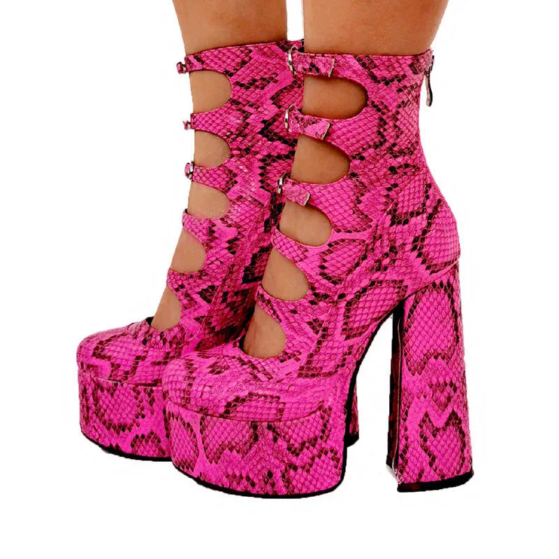 Women's black patent leather platform ankle boots with a serpentine belt buckle and thick rubber sole.