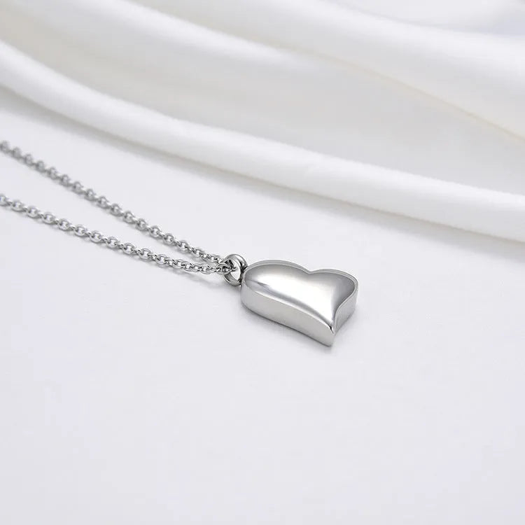 Silver curved peach heart stainless steel pendant necklace on a model, showing the adjustable chain length.