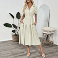 Light green women's shirtdress with lapel collar, waist tie, and side pockets.