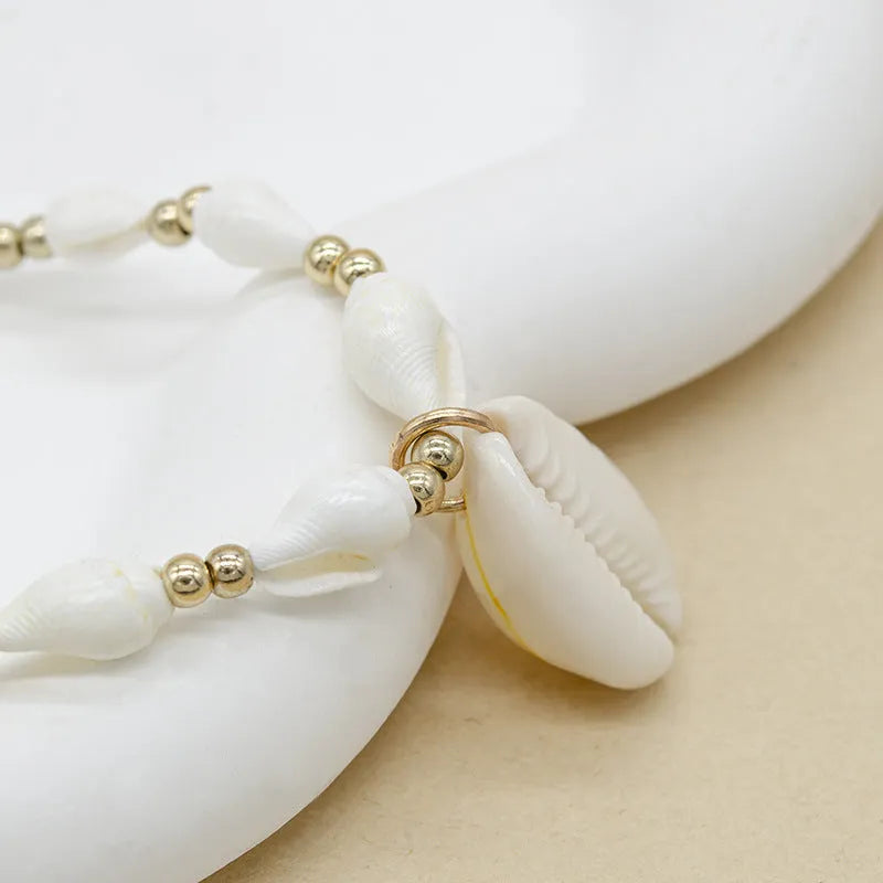 White conch shell pendant necklace on a regular chain, made from mother pearl shellfish.