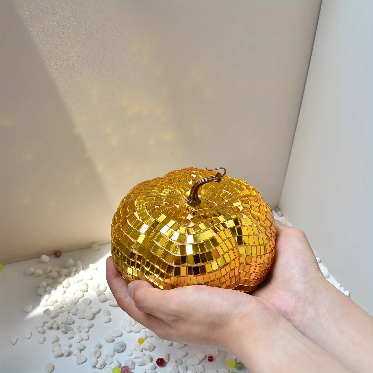 Chinese-style mirror glass pumpkin Halloween decoration in various sizes on a shelf.
