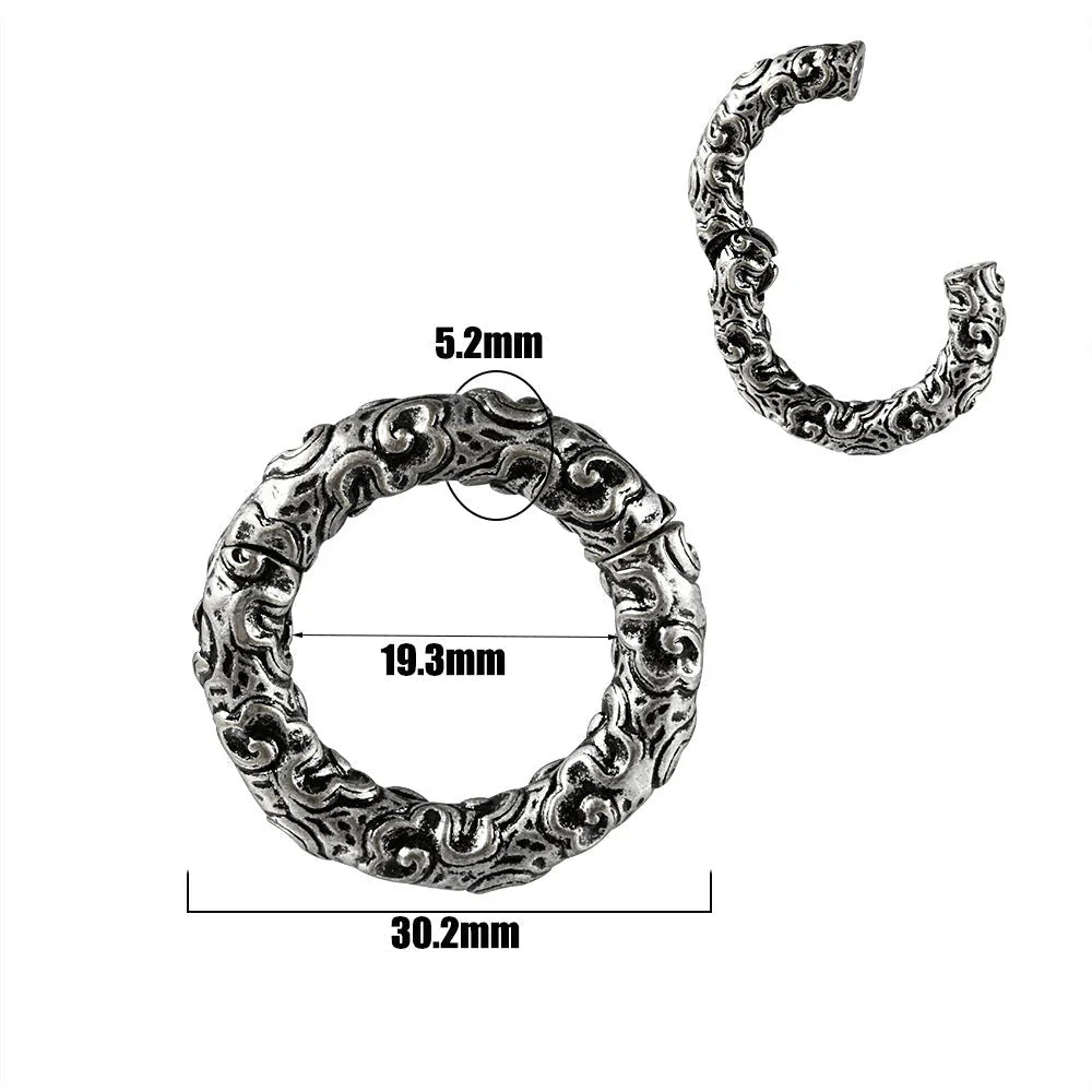 A pair of silver fashion earrings featuring a detailed totem pattern design on a stainless steel base.