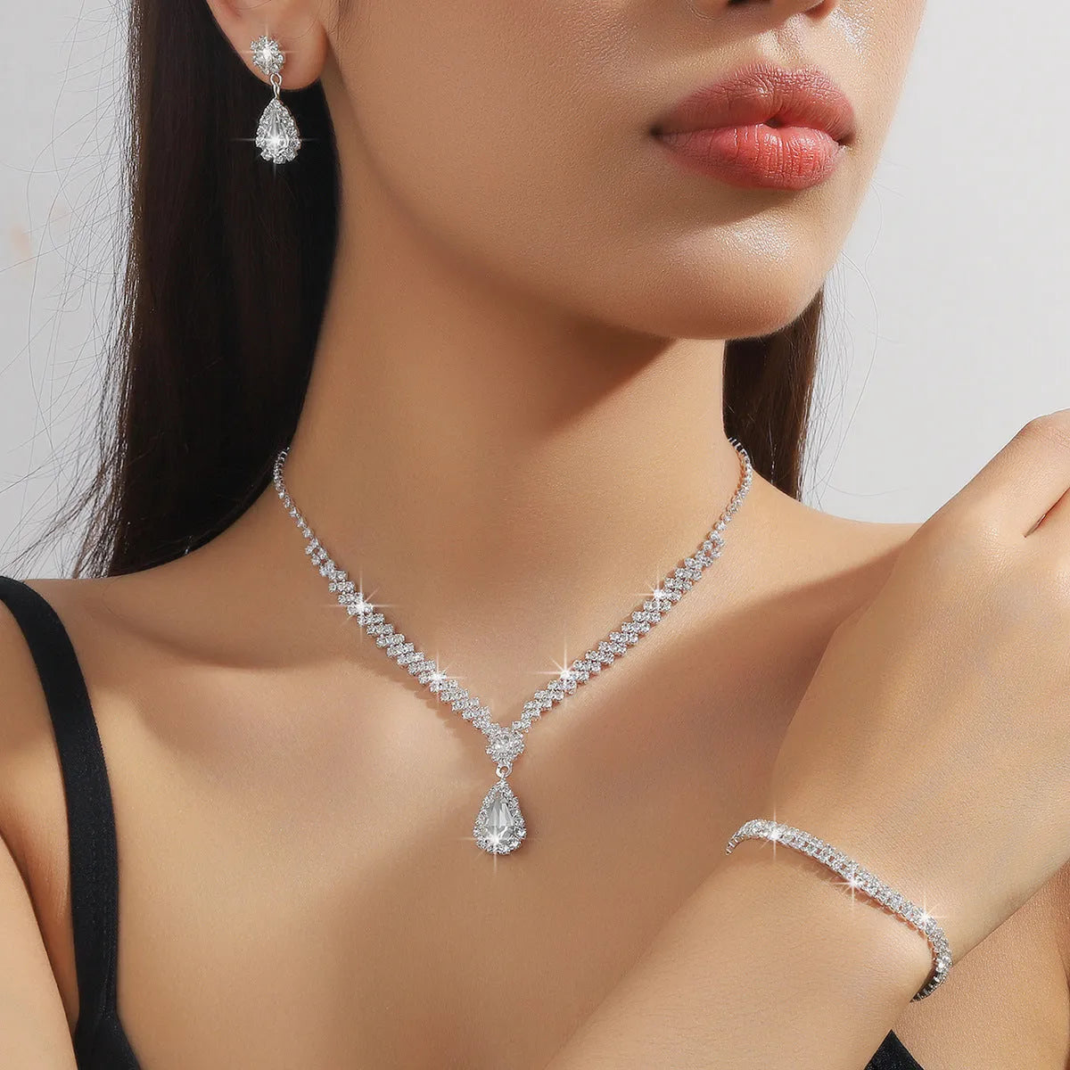 Claw chain necklace and matching earrings set with drop-shaped rhinestones in multiple colour options