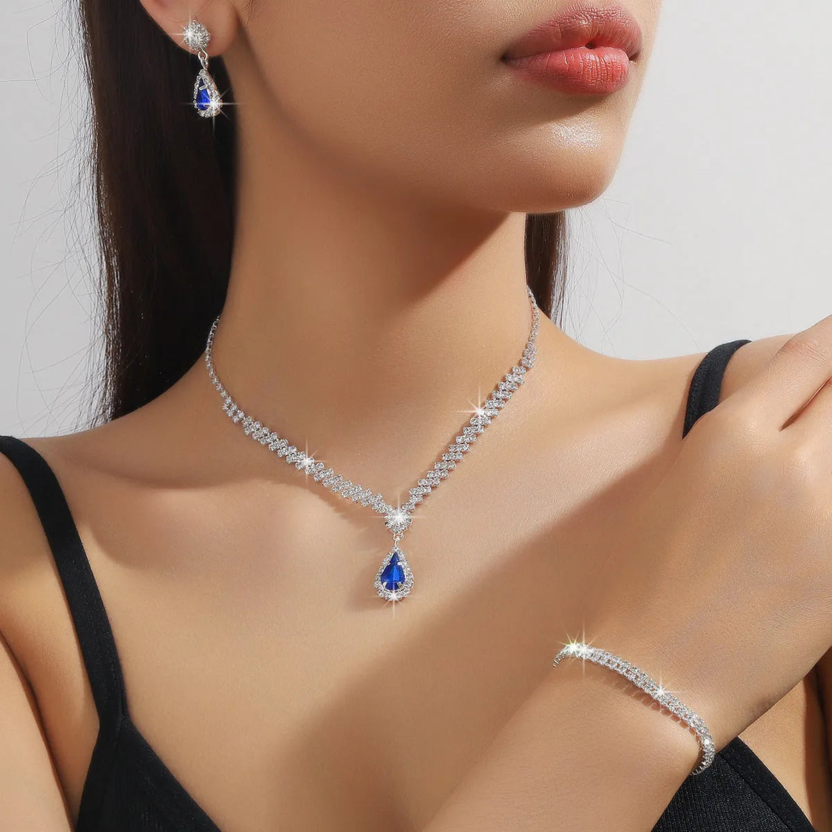 Claw chain necklace and matching earrings set with drop-shaped rhinestones in multiple colour options