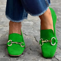 Green suede women's loafers with a round toe and silver metal fastener on a flat rubber sole.