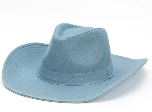 Brown leather velvet curved edge Western cowboy hat with a conical crown on a table.