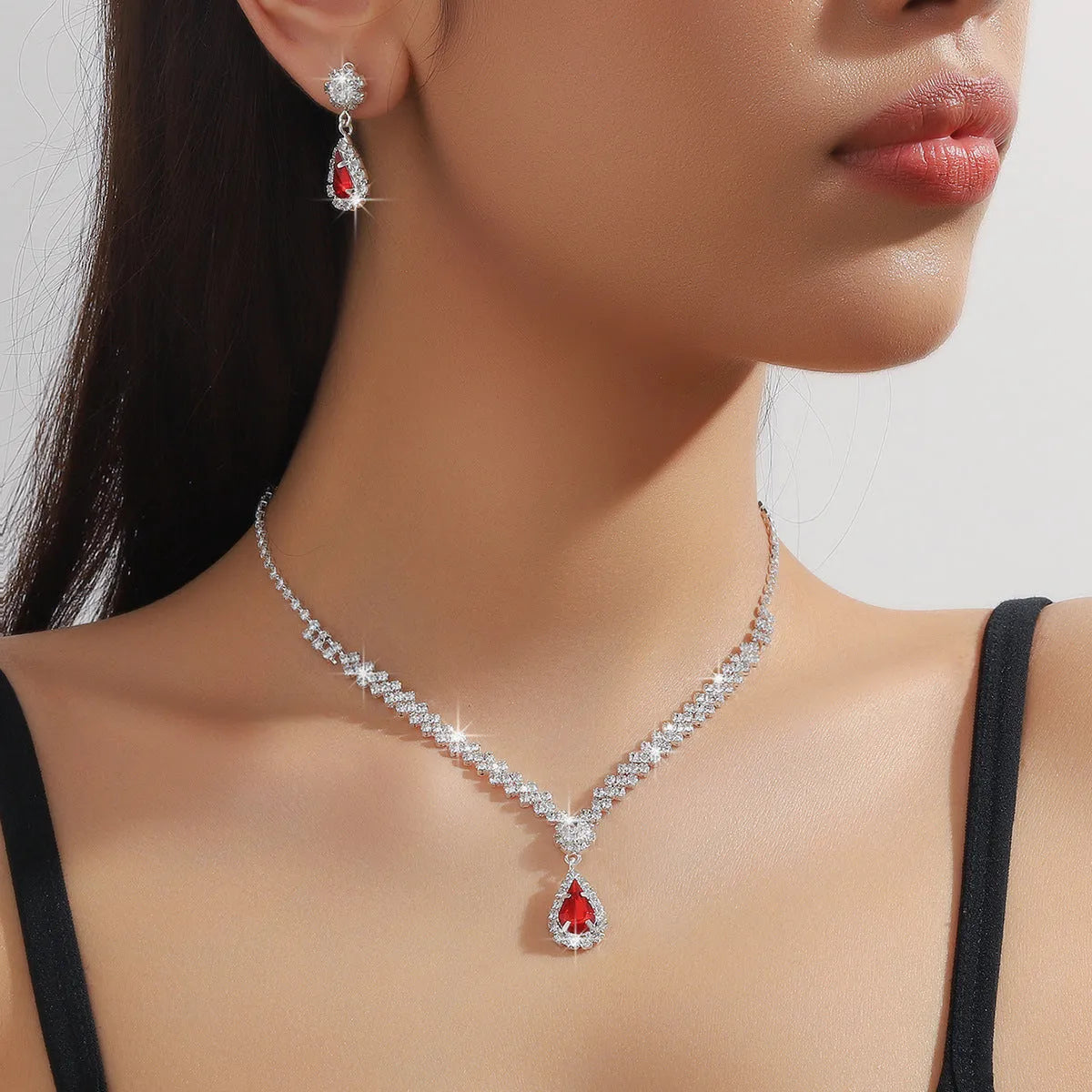 Claw chain necklace and matching earrings set with drop-shaped rhinestones in multiple colour options