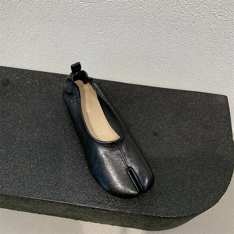 Women's black chunky low heel pumps with round toe and split toe horseshoe design on a rubber sole.
