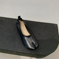 Women's black chunky low heel pumps with round toe and split toe horseshoe design on a rubber sole.