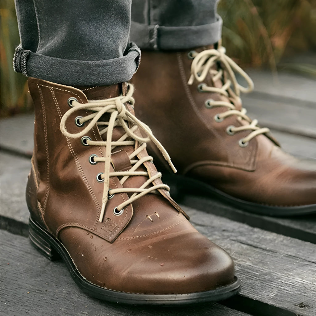 Men's black and brown two-tone leather boots with a side zip and low heel.