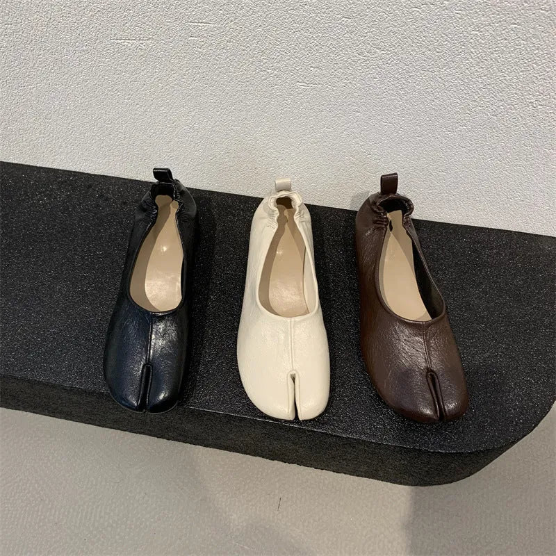 Women's black chunky low heel pumps with round toe and split toe horseshoe design on a rubber sole.