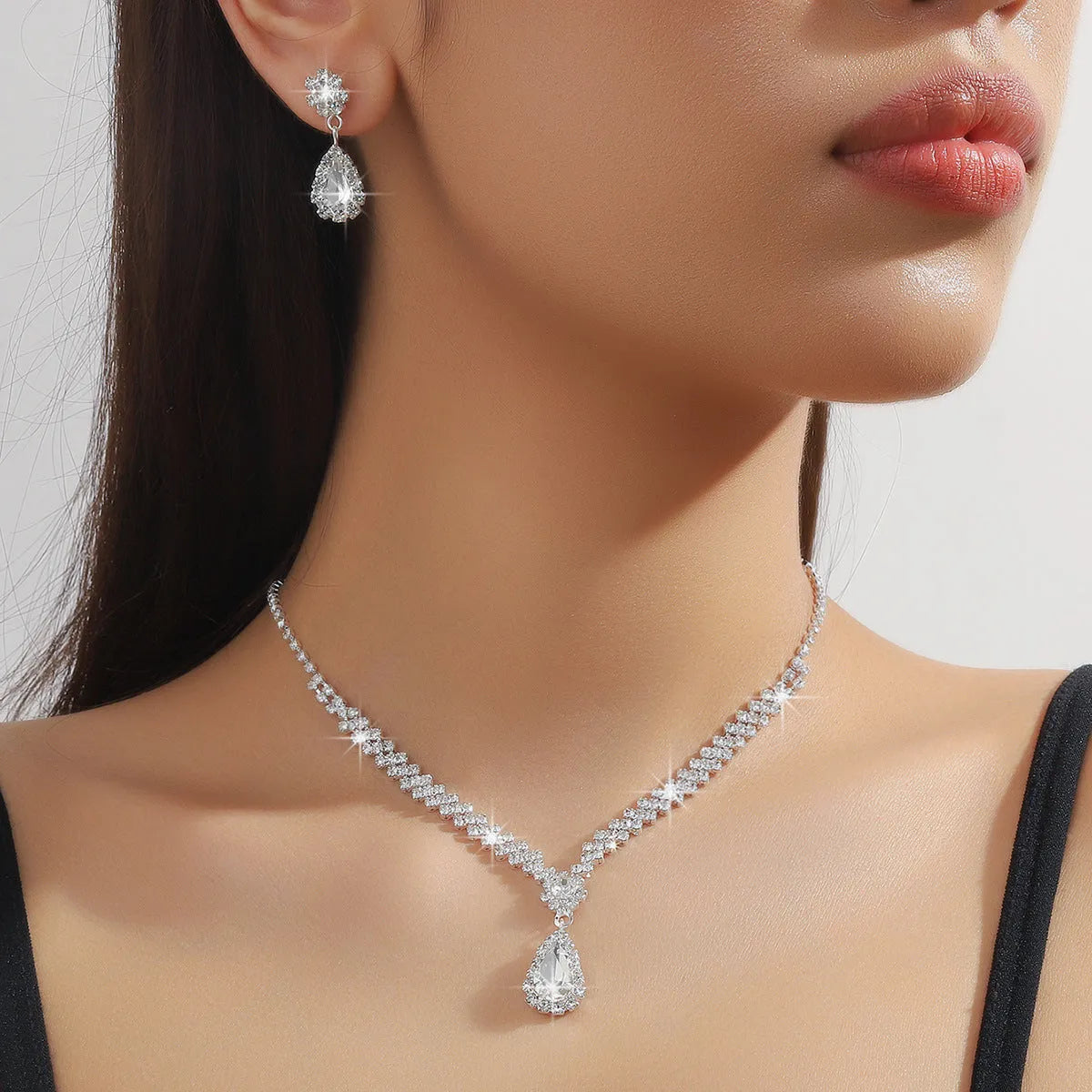 Claw chain necklace and matching earrings set with drop-shaped rhinestones in multiple colour options
