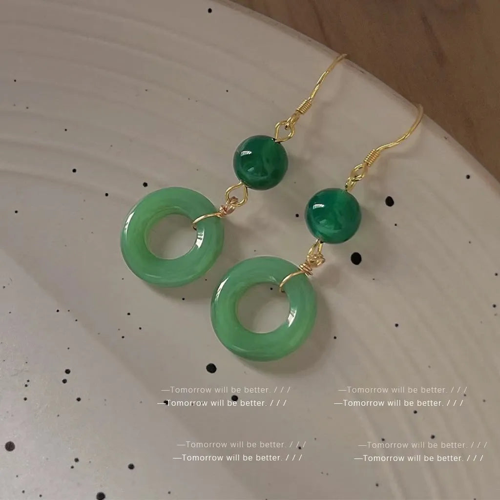 A pair of geometric green jade design Peace Buckle earrings in zinc alloy on a white background.