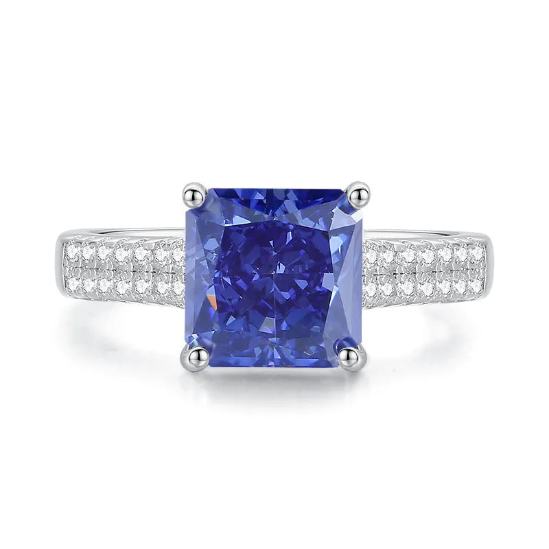 Women's heart-shaped sterling silver ring with ice flower cut coloured zircon stone on finger.
