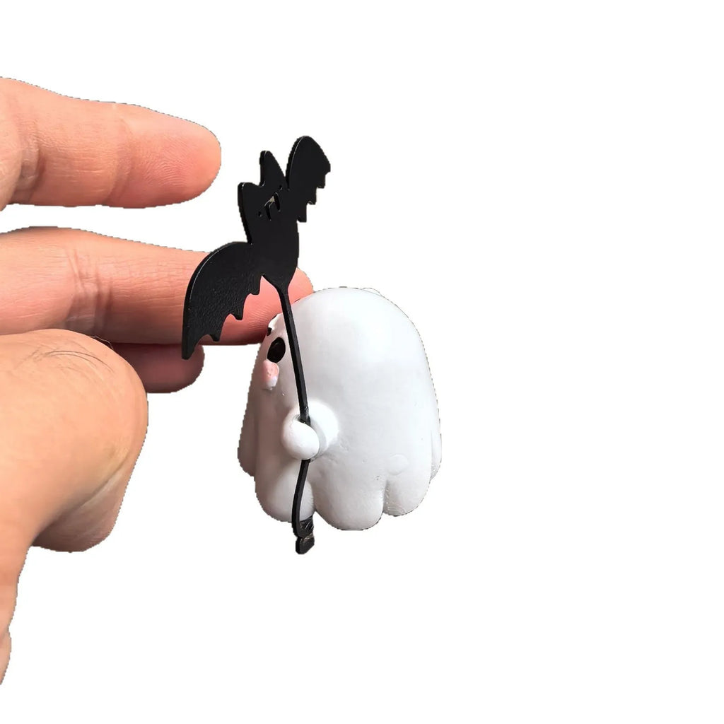 Small resin statue of a ghost holding a bat while walking a dog, a Halloween decoration.