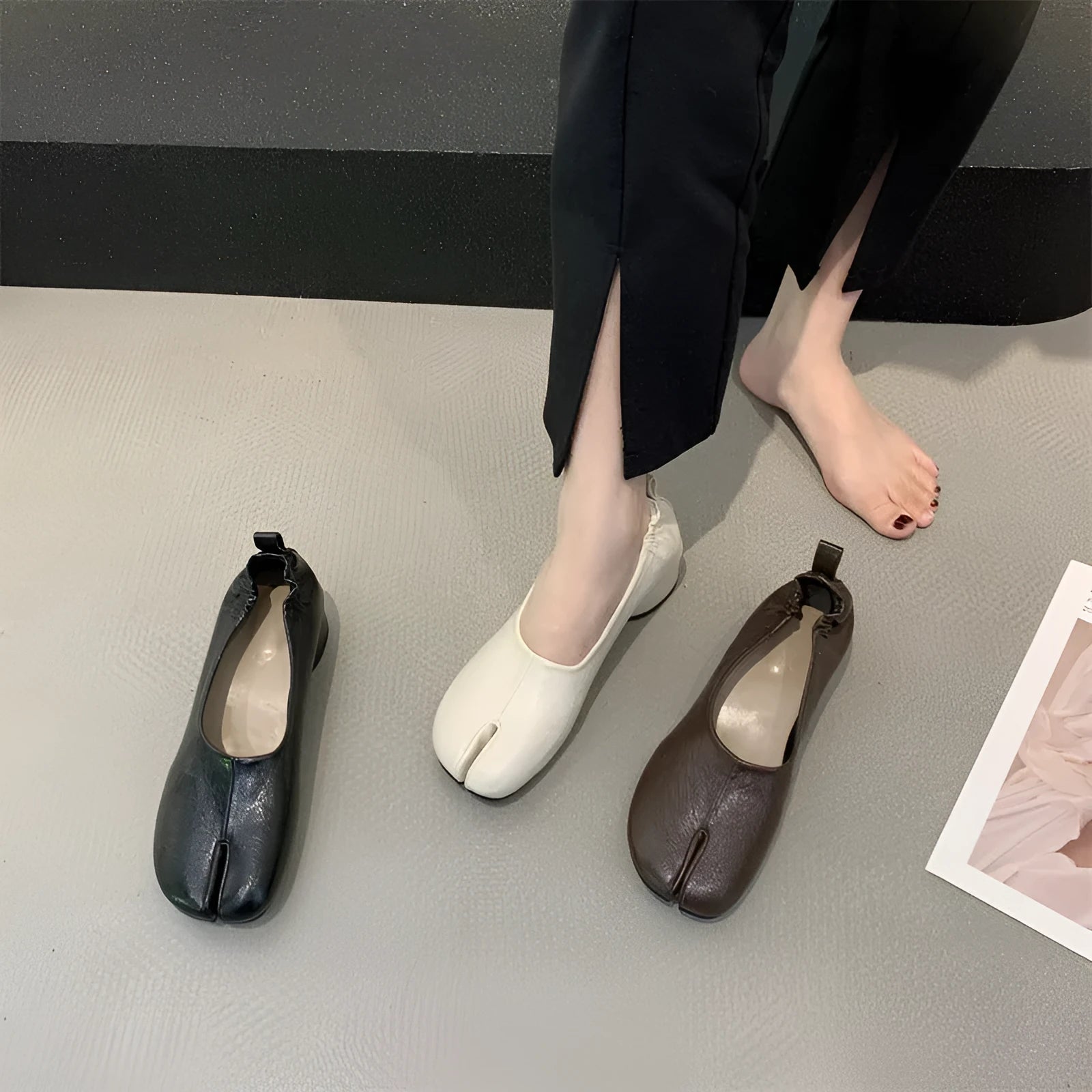 Women's black chunky low heel pumps with round toe and split toe horseshoe design on a rubber sole.