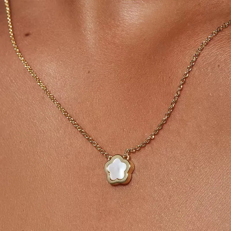 White mother shell flower necklace with floral pendant on gold or silver chain.